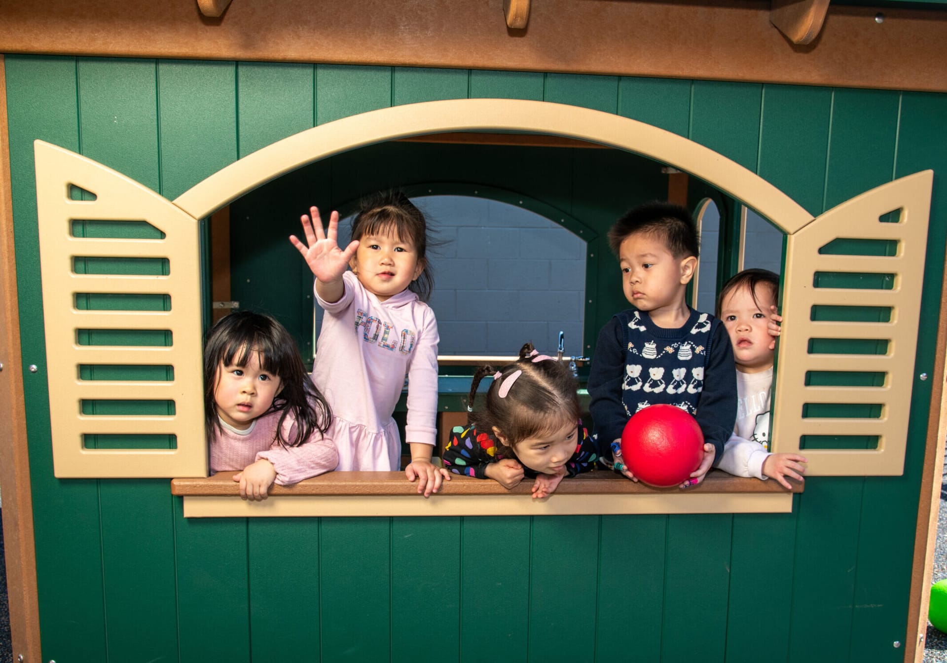 Asian children outdoors in a play house.