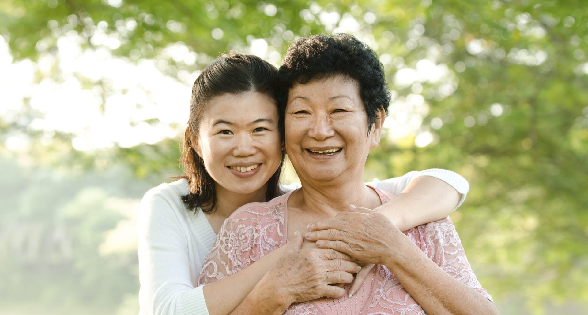 Asian mother and daughter hugging.